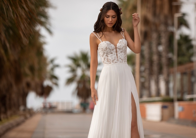 Model in the street on a hot day wearing thigh high split wedding dress