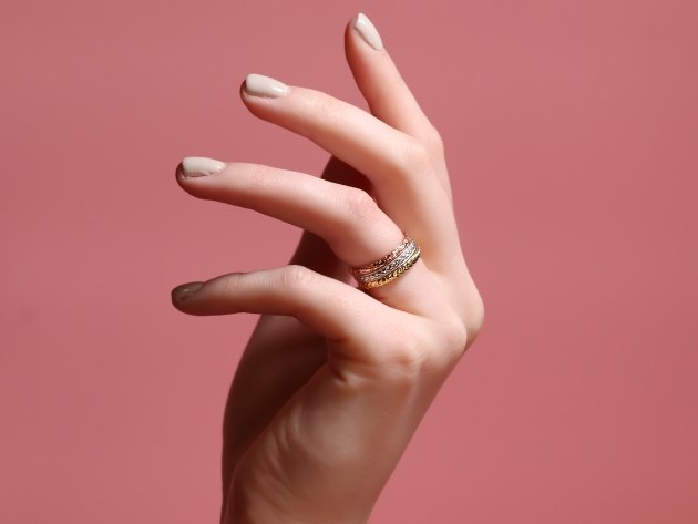 model's hand with a wedding band on