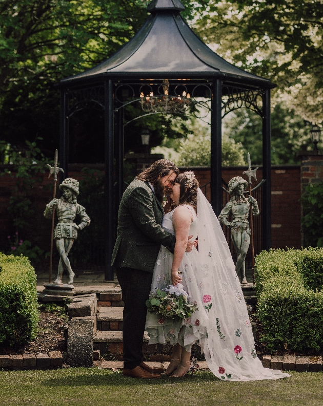 Couple kiss in front of the bandstand at Blakelands Country House