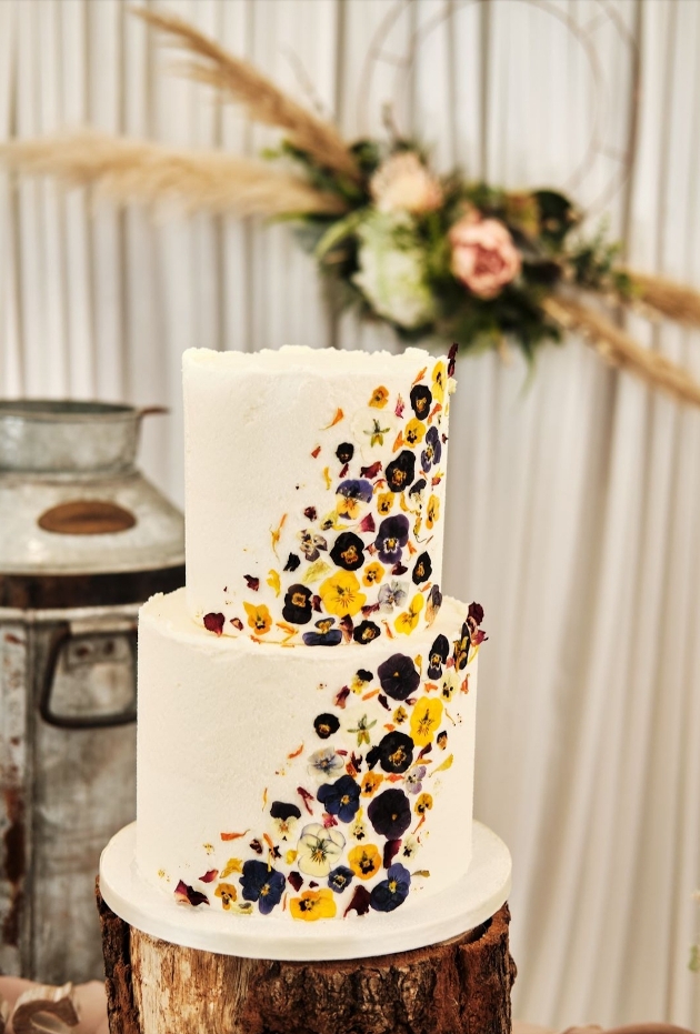 White wedding cake with coloured flowers inset