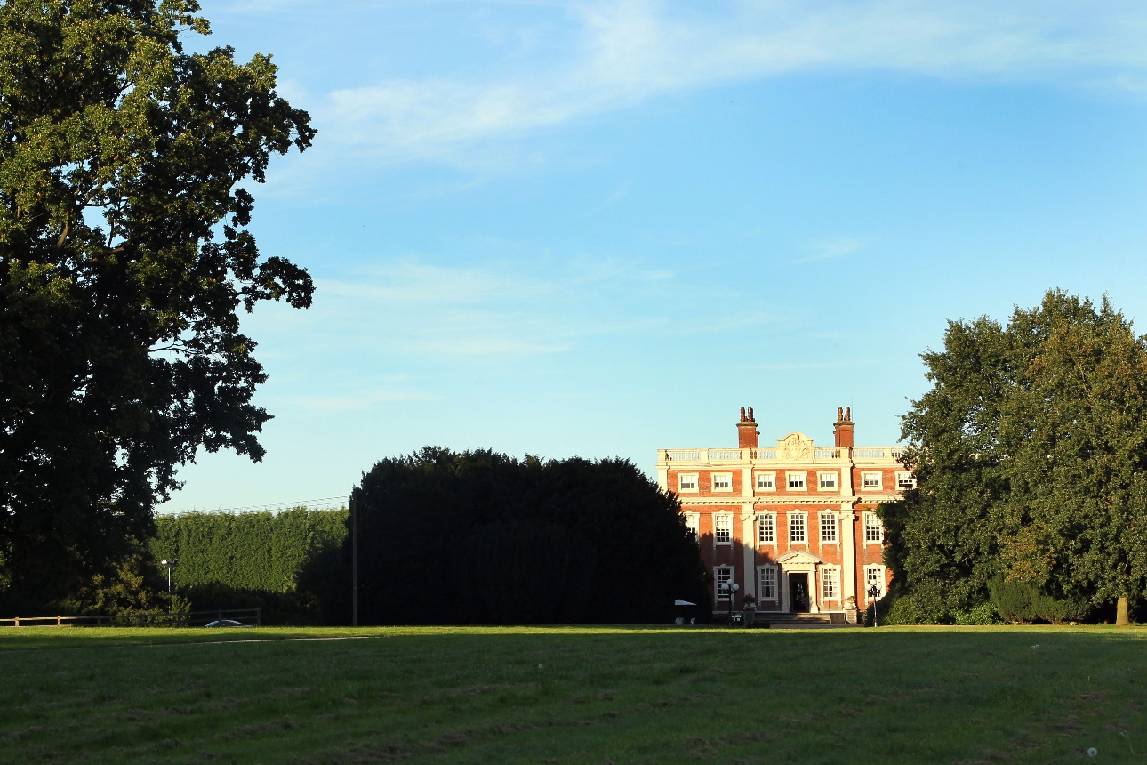 Swinken Hall Hotel stately home surrounded by grounds and tress on a blue sunny day