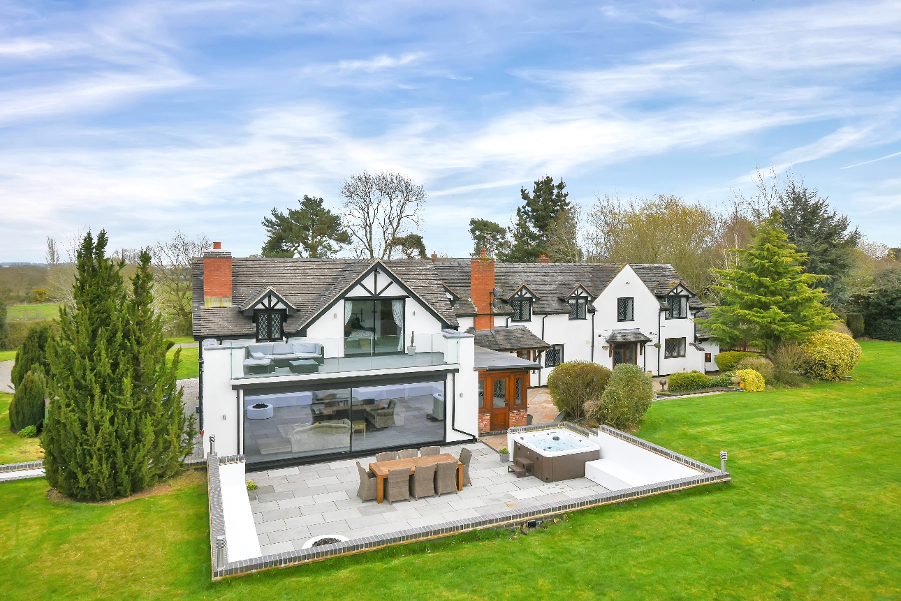 white country house with black tudor beams and modern extension hot tub and gardens