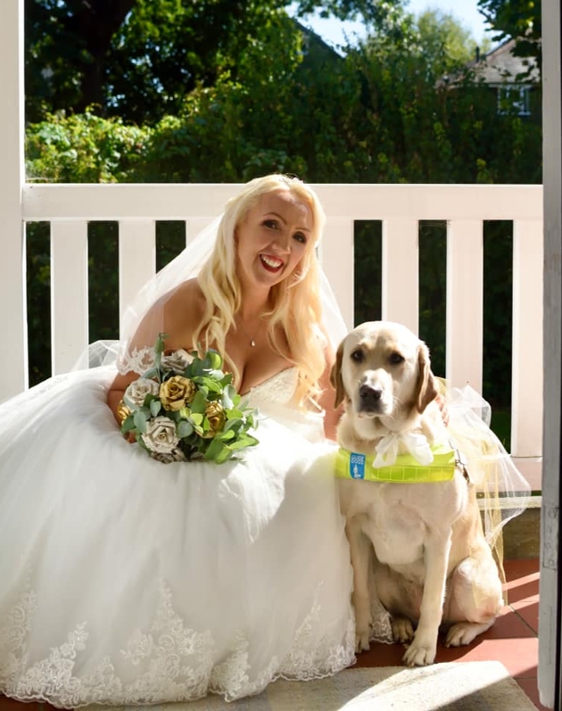 bride kneeling down with her guide dog