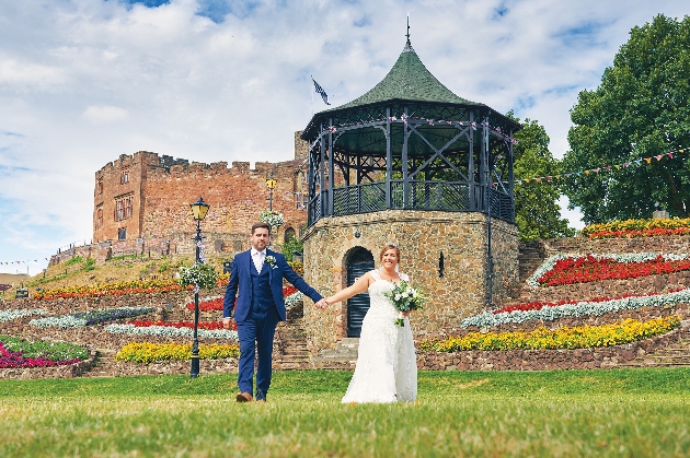 Bride and groom holding hands outside Tamworth Castle