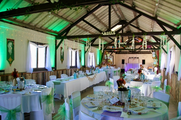 White tables and chairs inside a rustic barn