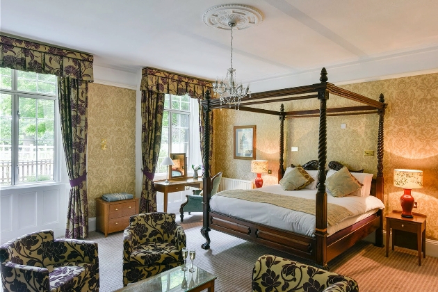 A bedroom with a four-poster bed and yellow and green furniture