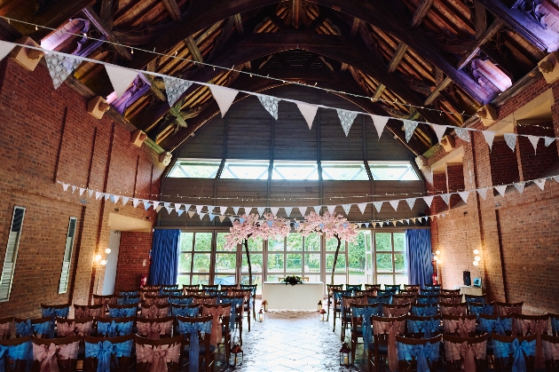 The interior of a large barn with a ceremony set up