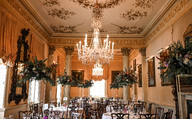 The interior of a grand orange room with columns and a painted ceiling